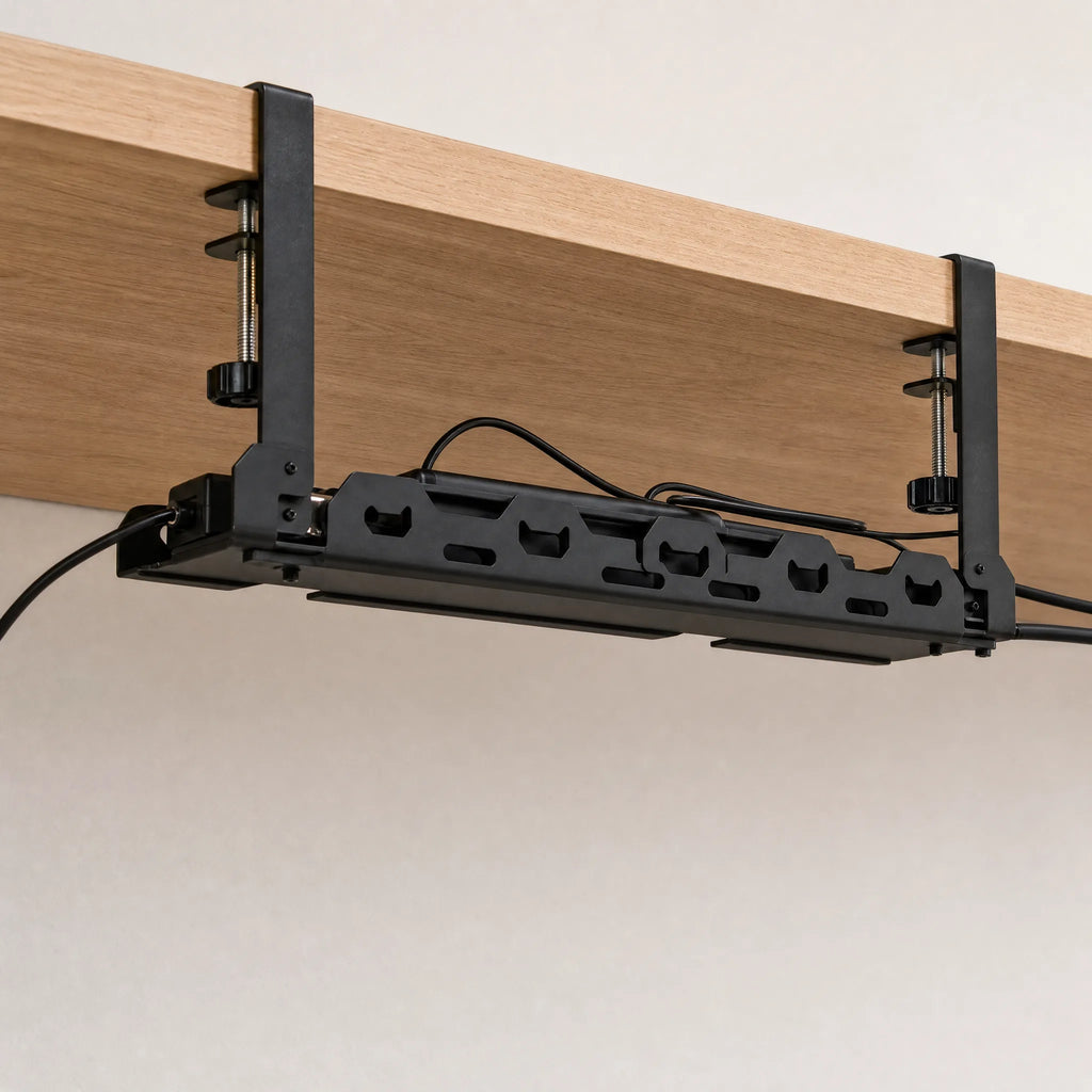 The cable tray clamped under a desk, holding a power strip and routed cables