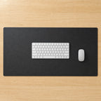 The desk pad on a desk with a keyboard and mouse, seen from above