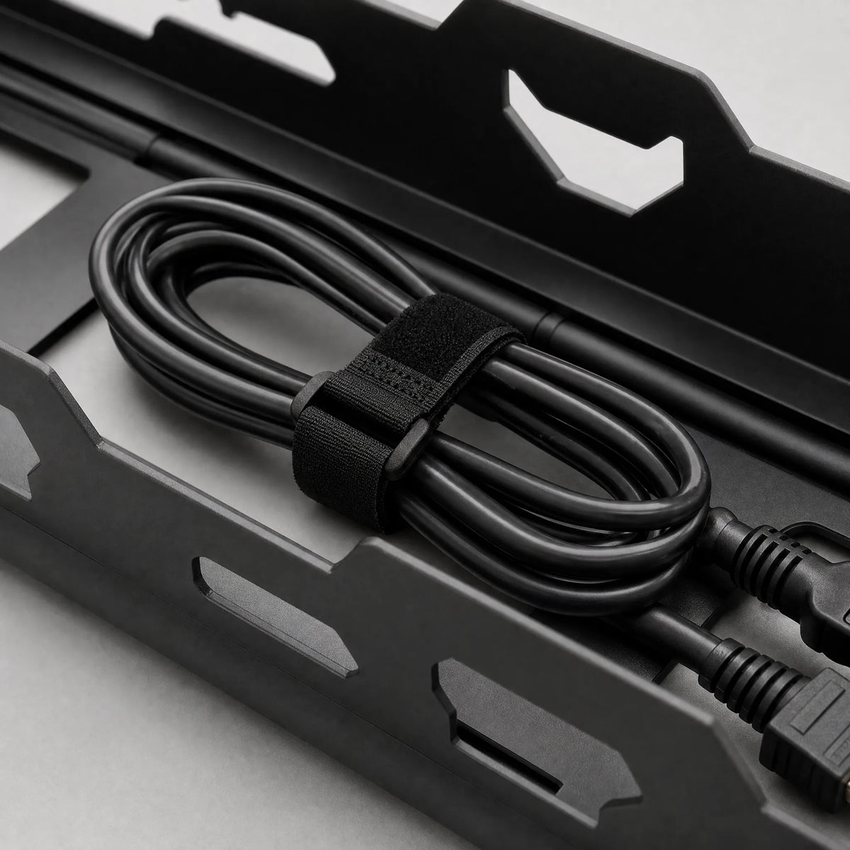 A cable bundle secured with a hook-and-loop strap inside the tray